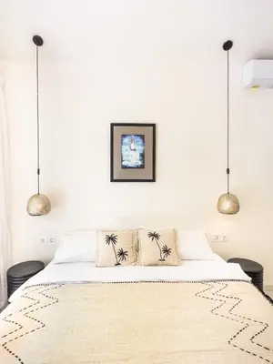 a bedroom with a bed with two pendant lights at Stylish 2bdr poolvilla Centre Seminyak in Seminyak