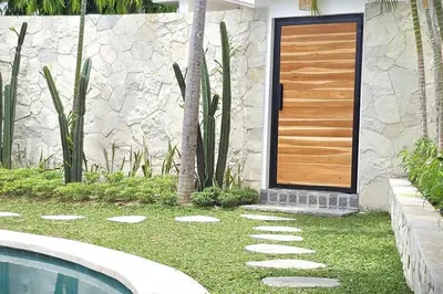 a house with a wooden door next to a swimming pool at Villa Kiara our Paradise in Seminyak 5 bedrooms 12m private pool in Seminyak