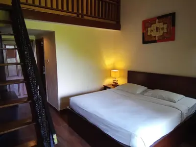a bedroom with a bed and a loft bed at Puri Dibia Kuta Hotel & Apartment in Kuta