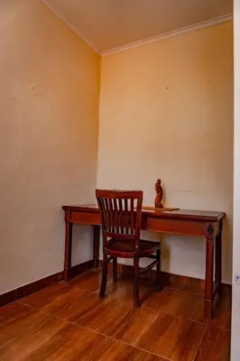 a chair sitting in front of a wooden desk at Puri Dibia Kuta Hotel & Apartment in Kuta