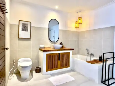a bathroom with a sink and a tub and a toilet at An Amazing 6BDR Private Family Villa with Pool in Tanah Lot