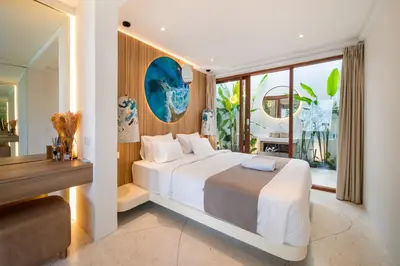a bedroom with a large white bed and a window at Magic Mango Villa Huge Projector bubble bath unique design in Canggu
