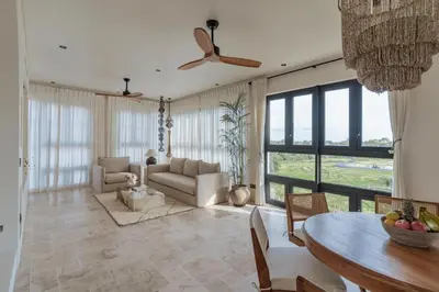 a living room with a ceiling fan and a table at The Revery Bali in Canggu