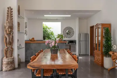 a kitchen and dining room with a wooden table and chairs at Villa Cempaka Ungu - Tranquil & Chic Pool 4-Bedroom Villa In The Heart Of Seminyak in Seminyak