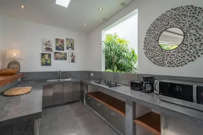 a kitchen with a sink and a microwave at Villa Cempaka Ungu - Tranquil & Chic Pool 4-Bedroom Villa In The Heart Of Seminyak in Seminyak