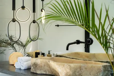 a bathroom with a stone sink on a counter at Rice field View with Sauna Projector and Jacuzzi Unique design in Canggu