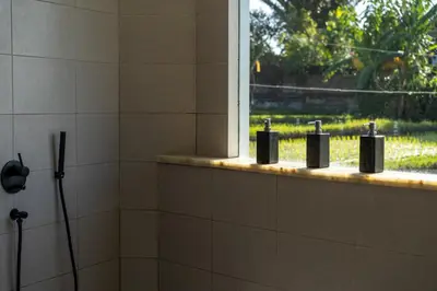 a bathroom with three soap bottles on a window at Rice field View with Sauna Projector and Jacuzzi Unique design in Canggu