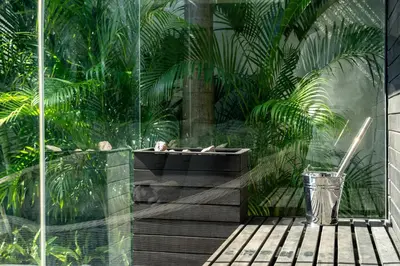 a garden with a bath tub and palm trees at Rice field View with Sauna Projector and Jacuzzi Unique design in Canggu