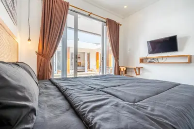 a bedroom with a large bed and a large window at Lumturi House - Centrally Located in Seminyak