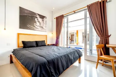 a bedroom with a bed and a large window at Lumturi House - Centrally Located in Seminyak
