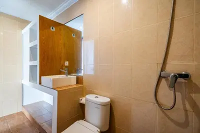 a bathroom with a toilet and a sink and a shower at Lumturi House - Centrally Located in Seminyak