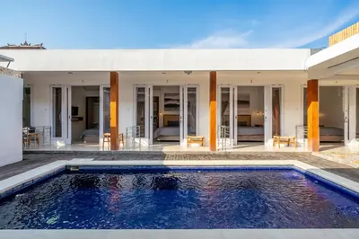 a swimming pool in front of a house at Lumturi House - Centrally Located in Seminyak