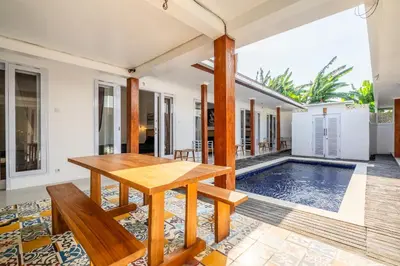 a dining room with a table and a pool at Lumturi House - Centrally Located in Seminyak