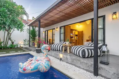a house with a swimming pool with two inflatable swans at Kalya Villa by RPM in Seminyak