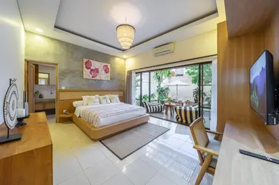 a bedroom with a bed and a television in it at Kalya Villa by RPM in Seminyak