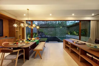 a kitchen with a table and a dining room at Kolila Villa Seminyak by Ini Vie Hospitality in Seminyak