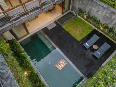 an overhead view of a pool with two chairs and a table at Kolila Villa Seminyak by Ini Vie Hospitality in Seminyak