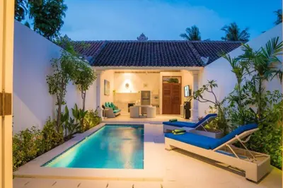 a villa with a swimming pool in front of a house at Villa Ley Hidden Gem Villa 1 Bedroom Private Pool Seminyak in Seminyak