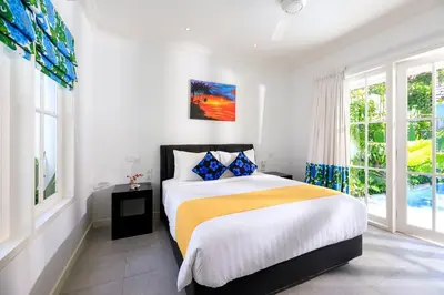 a white bedroom with a bed and windows at Villa Ley Hidden Gem Villa 1 Bedroom Private Pool Seminyak in Seminyak