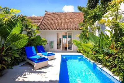 a villa with a swimming pool in front of a house at Villa Ley Hidden Gem Villa 1 Bedroom Private Pool Seminyak in Seminyak