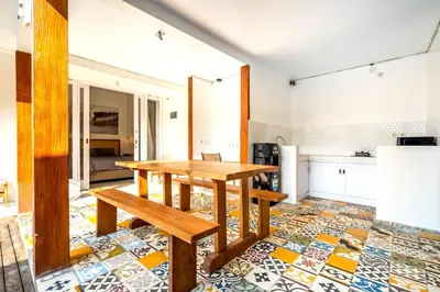 a dining room with a table and a kitchen at Lumturi House - Centrally Located in Seminyak