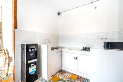 a kitchen with white cabinets and a refrigerator at Lumturi House - Centrally Located in Kerobokan