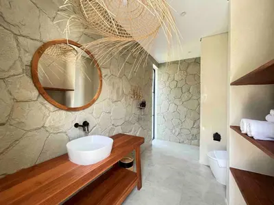 a bathroom with a sink and a mirror at Villa Anwa Cove - Gorgeous 6-BR & 2-Pool Villa in Bali in Umalas