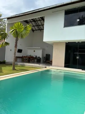 a swimming pool in front of a house at Villa Lina, Nusa Dua Benoa in Nusa Dua