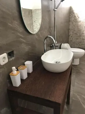 a bathroom with a sink and a toilet and a mirror at Villa Lina, Nusa Dua Benoa in Nusa Dua