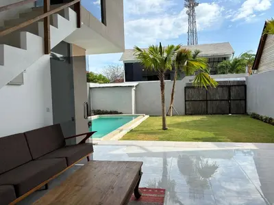 a living room with a couch and a pool at Villa Lina, Nusa Dua Benoa in Nusa Dua