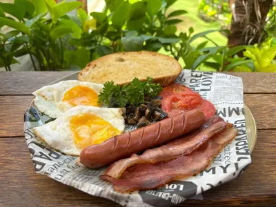 a plate of breakfast food with eggs bacon and toast at Villa Lina, Nusa Dua Benoa in Nusa Dua