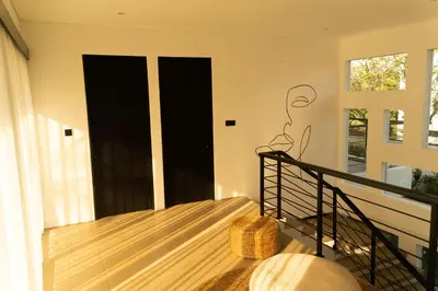 a balcony with black doors and a wicker basket at Admire Villa - a luxury private villa with Pool in Legian