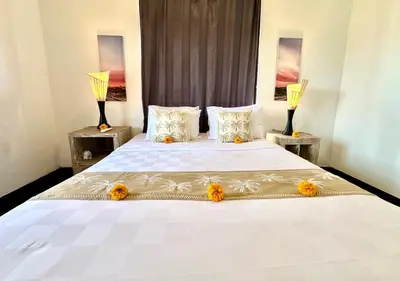 a bedroom with a large white bed with flowers on it at Casa Sessy Legian in Seminyak