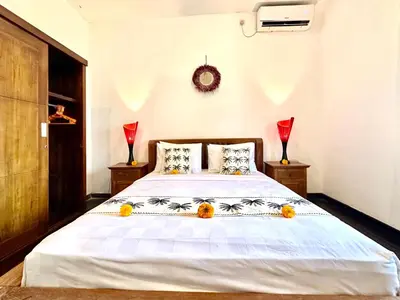 a bedroom with a bed with oranges on it at Casa Sessy Legian in Seminyak