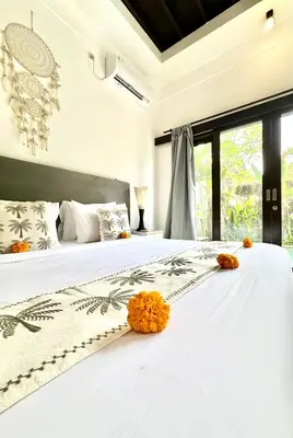 a bedroom with a white bed with orange flowers on it at Casa Sessy Legian in Seminyak