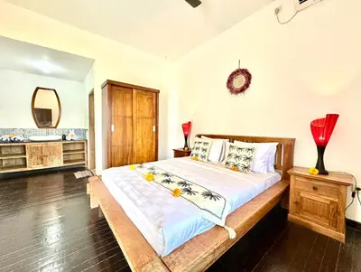a bedroom with a large bed with a wooden frame at Casa Sessy Legian in Seminyak