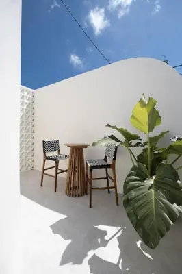 a patio with two chairs and a table and a plant at Casa Z - Seminyak 3BR Villa with Private Pool in Seminyak