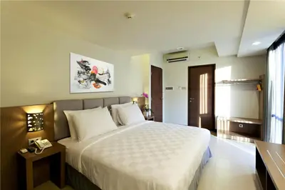 a bedroom with a large bed in a room at Euphoria Hotel in Legian