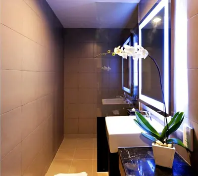 a bathroom with a sink and a mirror at Euphoria Hotel in Legian