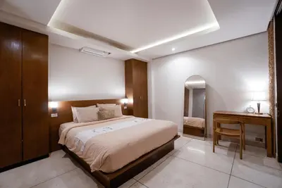 a bedroom with a large bed and a desk at Villa Duadewi 4BR in the Heart of Seminyak by Santi Management in Seminyak