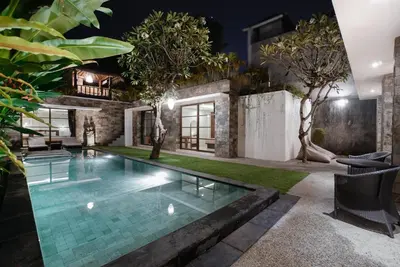 a pool in the backyard of a house at night at Villa Duadewi 4BR in the Heart of Seminyak by Santi Management in Seminyak