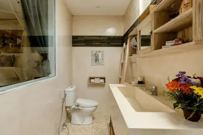 a bathroom with a toilet and a sink and a vase of flowers at Luxurious Double King Villa w/Pool & WiFi+ Carpark in Seminyak