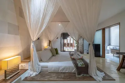 a bedroom with a large white bed with curtains at Balinese Luxury Amisha Villa: 4BR in Seminyak in Seminyak