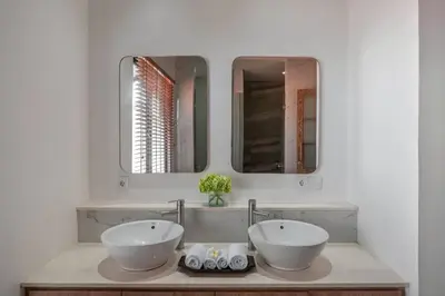 a bathroom with two sinks and two mirrors at Balinese Luxury Amisha Villa: 4BR in Seminyak in Seminyak