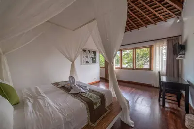 a bedroom with a canopy bed and a desk at Balinese Luxury Amisha Villa: 4BR in Seminyak in Seminyak