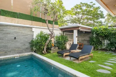 a backyard with two chairs and a swimming pool at 2 Br Villa in Seminyak with private Pool and Parking in Seminyak