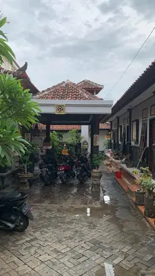 a group of motorcycles parked outside of a building at Tirtasuci House in Kuta