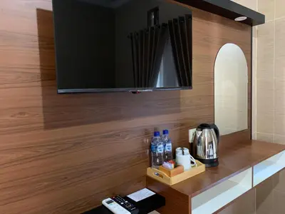 a room with a counter with a tv on a wall at Tirtasuci House in Kuta