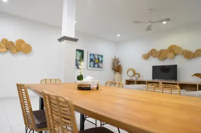 a dining room with a wooden table and chairs at Nossa Casa Villa in Seminyak