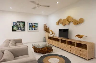 a living room with a tv and a couch and a table at Nossa Casa Villa in Seminyak